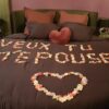Demande en mariage en pétales sur le lit